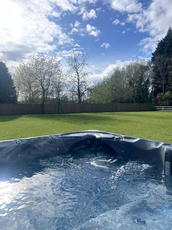 a pool of water in a backyard with a yard at Marzion House with Hot Tub in Tattershall Thorpe