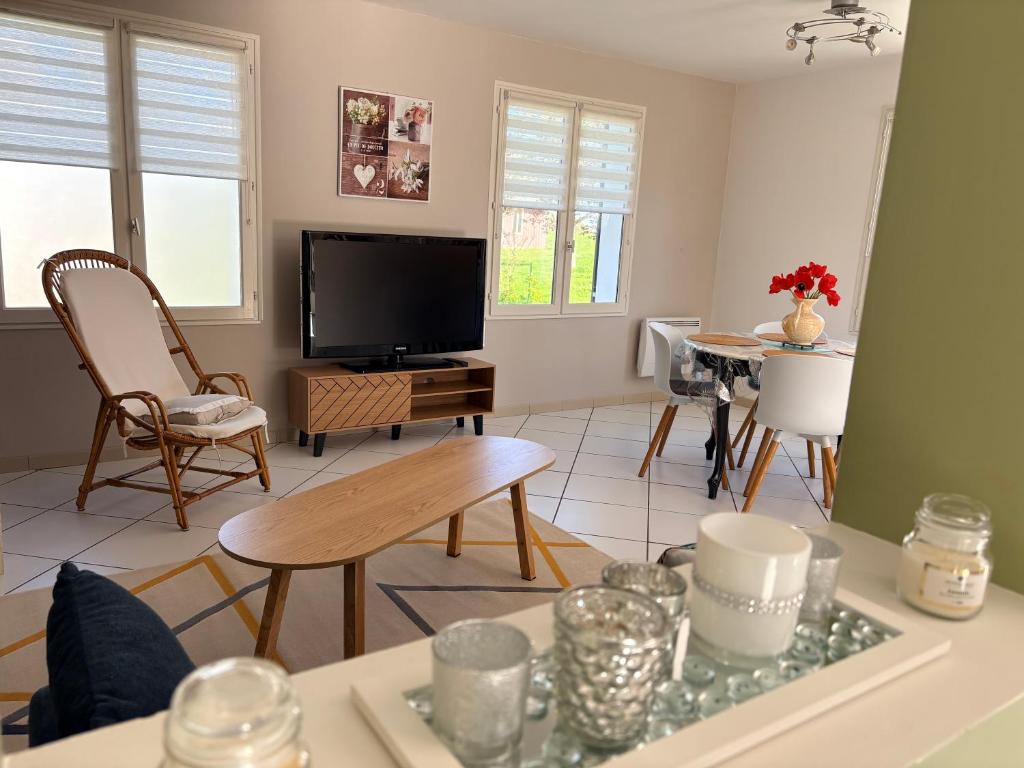 a living room with a tv and a table at Mon calme in Arques-la-Bataille
