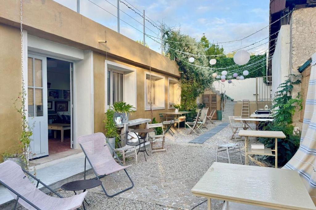 a patio with tables and chairs and a building at beachhousebarn in Vendays-Montalivet