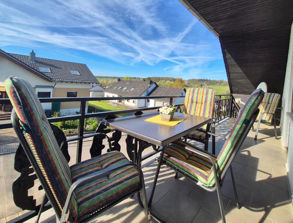 a table and chairs on a balcony with a view at Ferienwohnung Marx in Konz