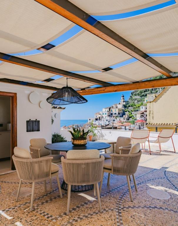 a patio with a table and chairs and a view at AmalfiRa Luxury Seaview Rooftop in Amalfi