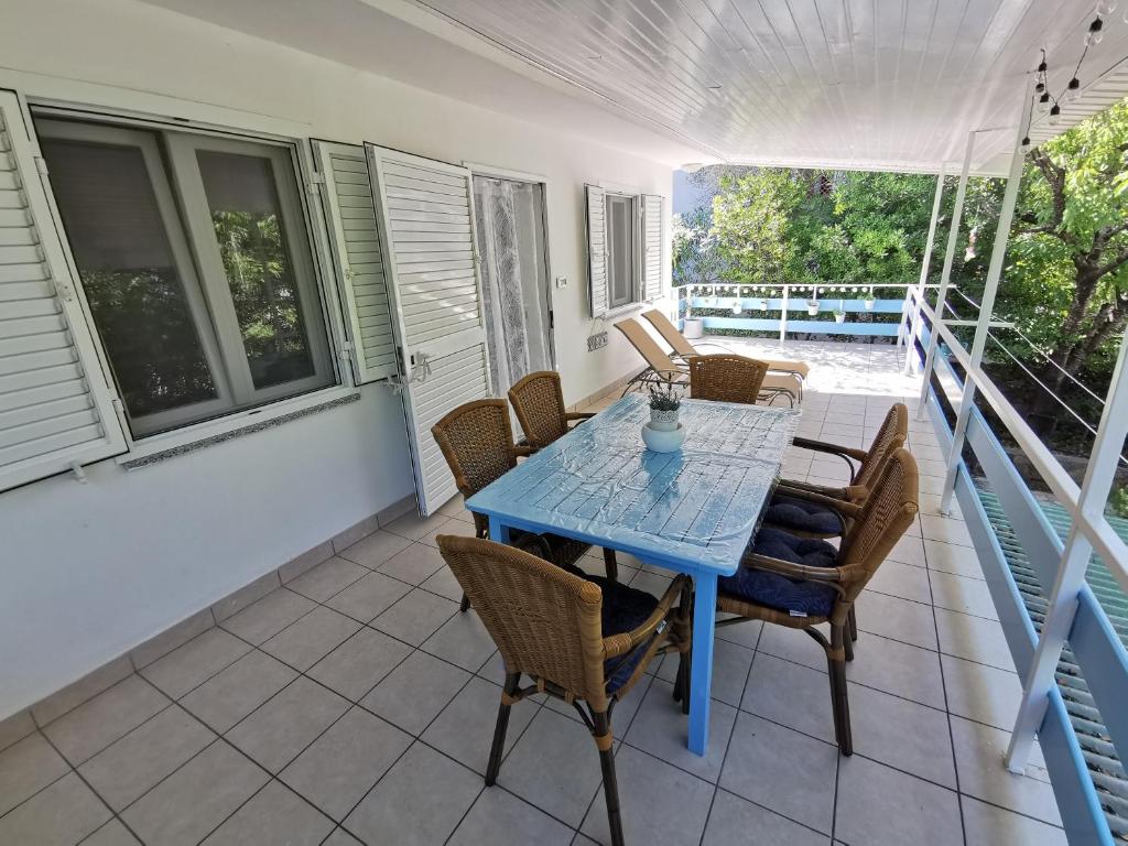 a blue table and chairs on a porch at Apartman Magdalena in Cres