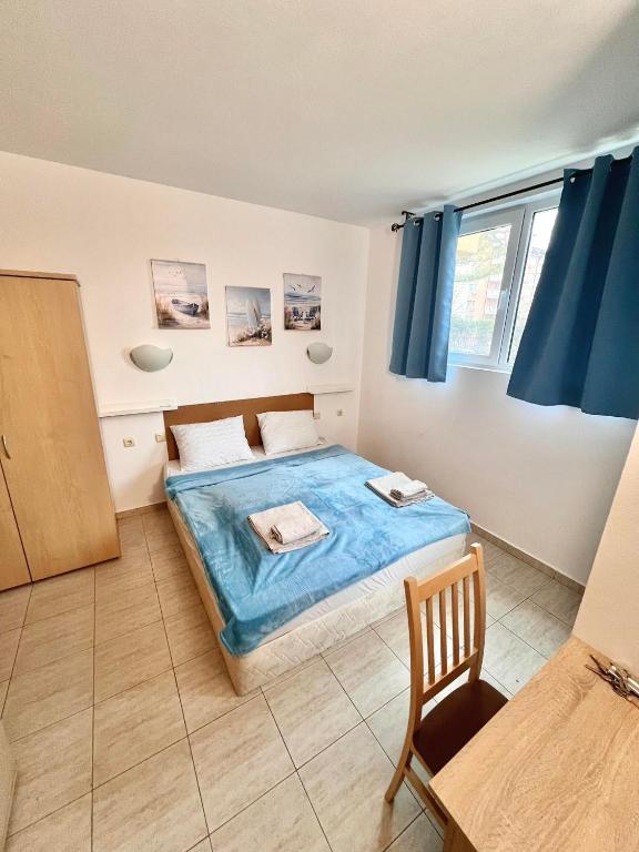 a bedroom with a bed with a blue blanket at Polo Resort studio in Sunny Beach