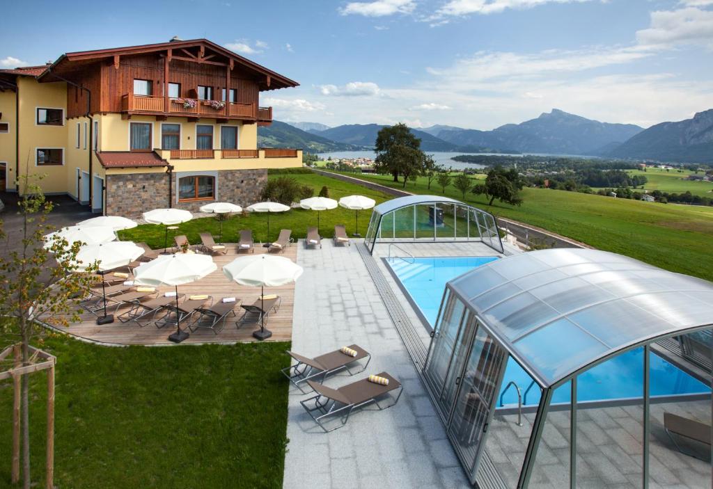 a villa with a swimming pool and a house at Panorama Hotel Leidingerhof in Mondsee