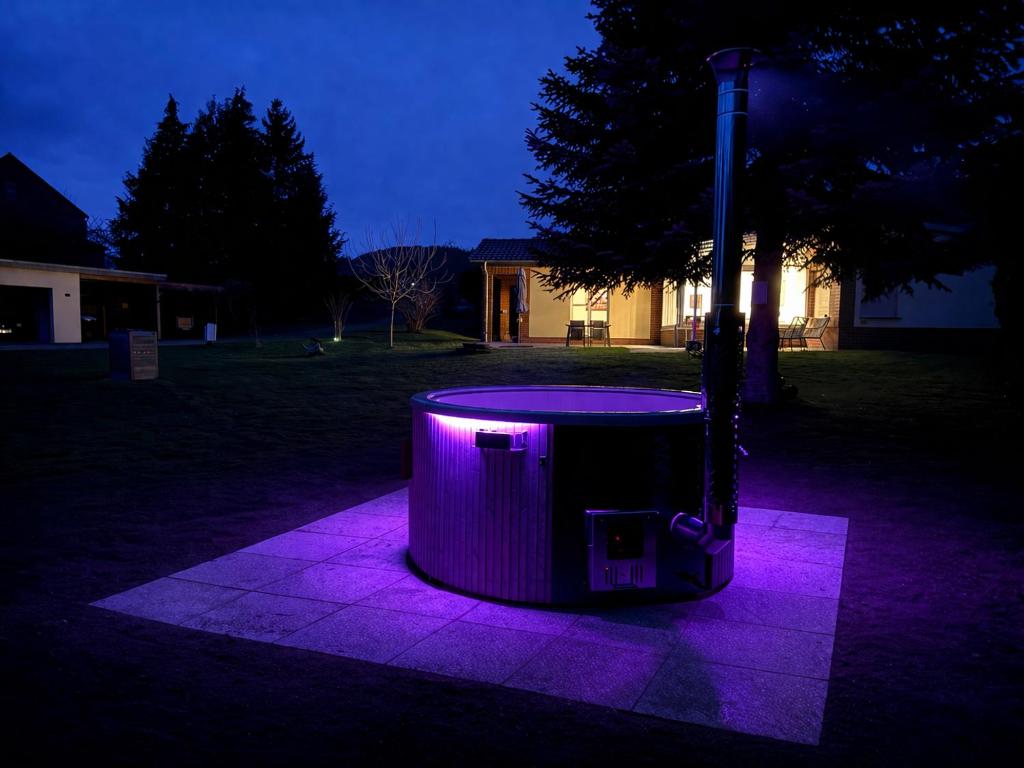 a purple lighted trash can in a yard at night at Ferienoase Eisvogel in Malchin