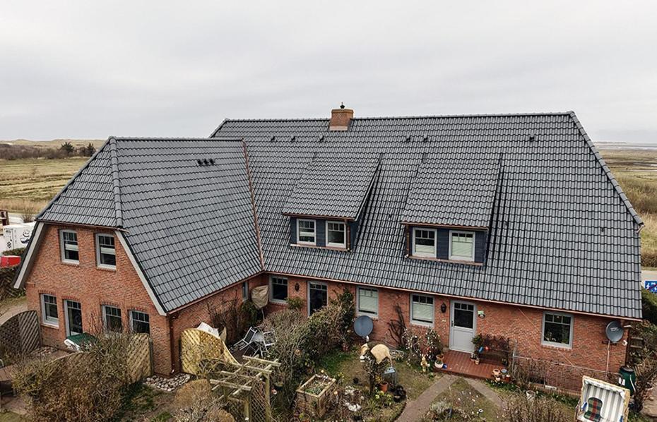 a house with a roof on top of it at Sütjers Hüs in Norddorf