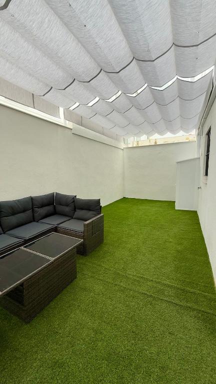 a living room with a couch and green carpet at Azahar Home Sevilla in Seville