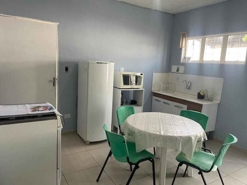 a kitchen with a table and chairs and a refrigerator at Casa para 8 pessoas in Itu