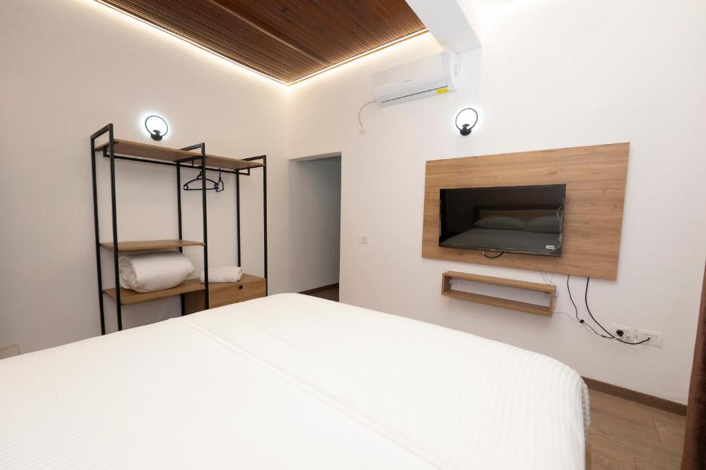 a bedroom with a bed and a tv on a wall at Bar Hotel Orgito in Lushnjë
