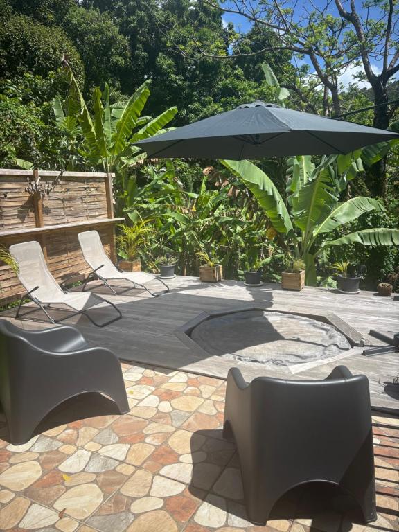 a group of chairs and an umbrella on a patio at Le Bananawi in Pointe-Noire