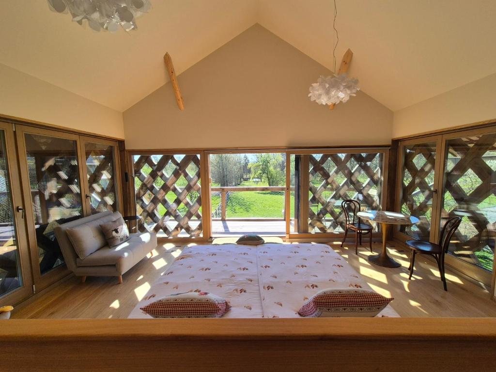 a bedroom with a large bed in a room with windows at Cosy Village in Šentjernej
