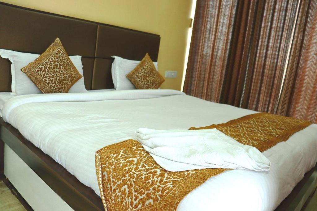 a bedroom with a large bed with white sheets and pillows at Harsh-Regency in Rānchī