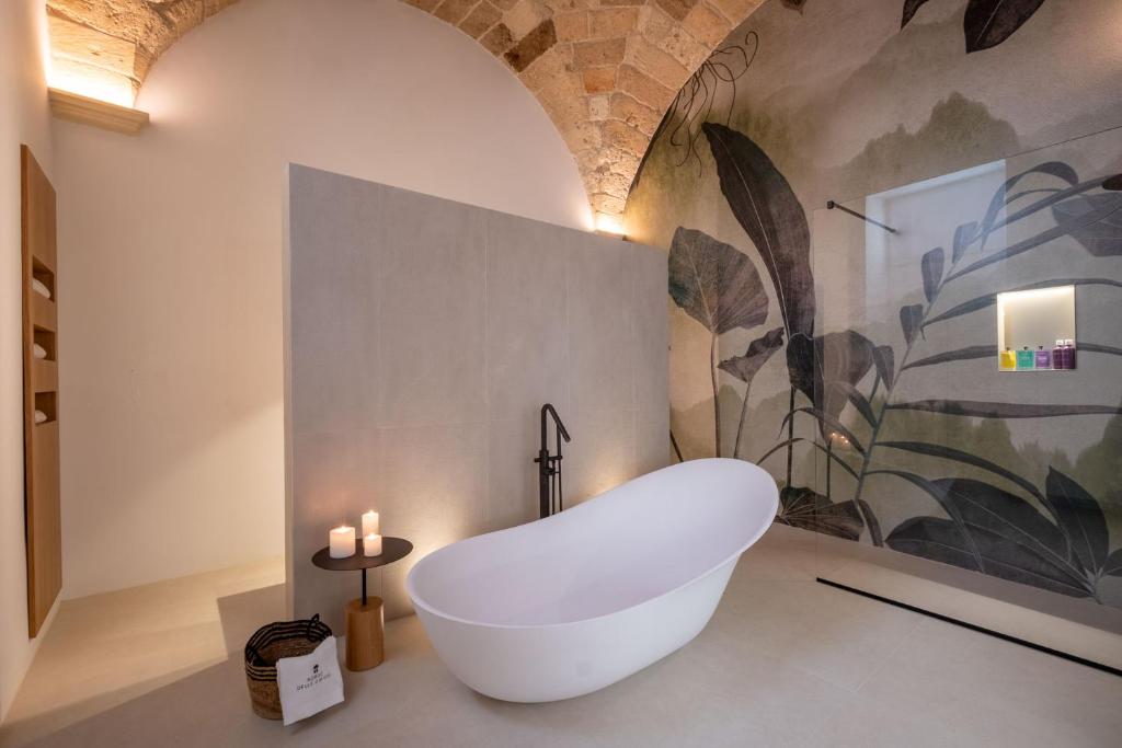 a white bath tub in a bathroom with candles at Borgo delle Dimore in Maglie