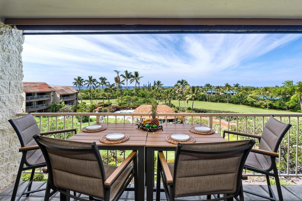 a wooden table with chairs on a balcony at Keauhou Punahele#B-207 in Kailua-Kona