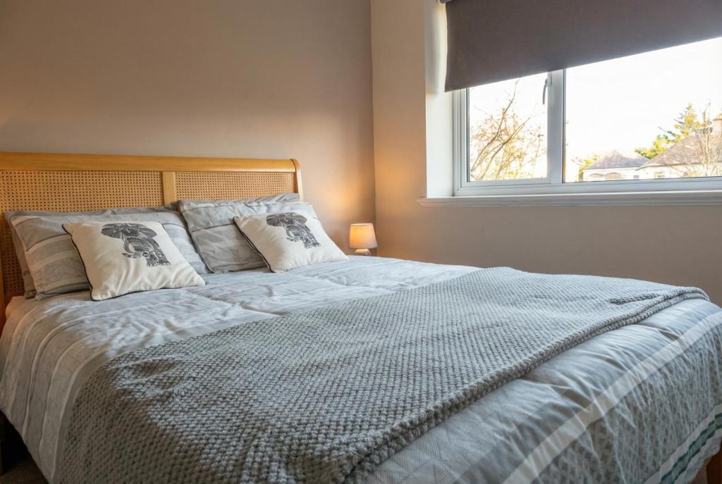 a bedroom with a large bed with a window at Stylish Morpeth Cottage with Log Burner, Garden and Free Parking in Morpeth