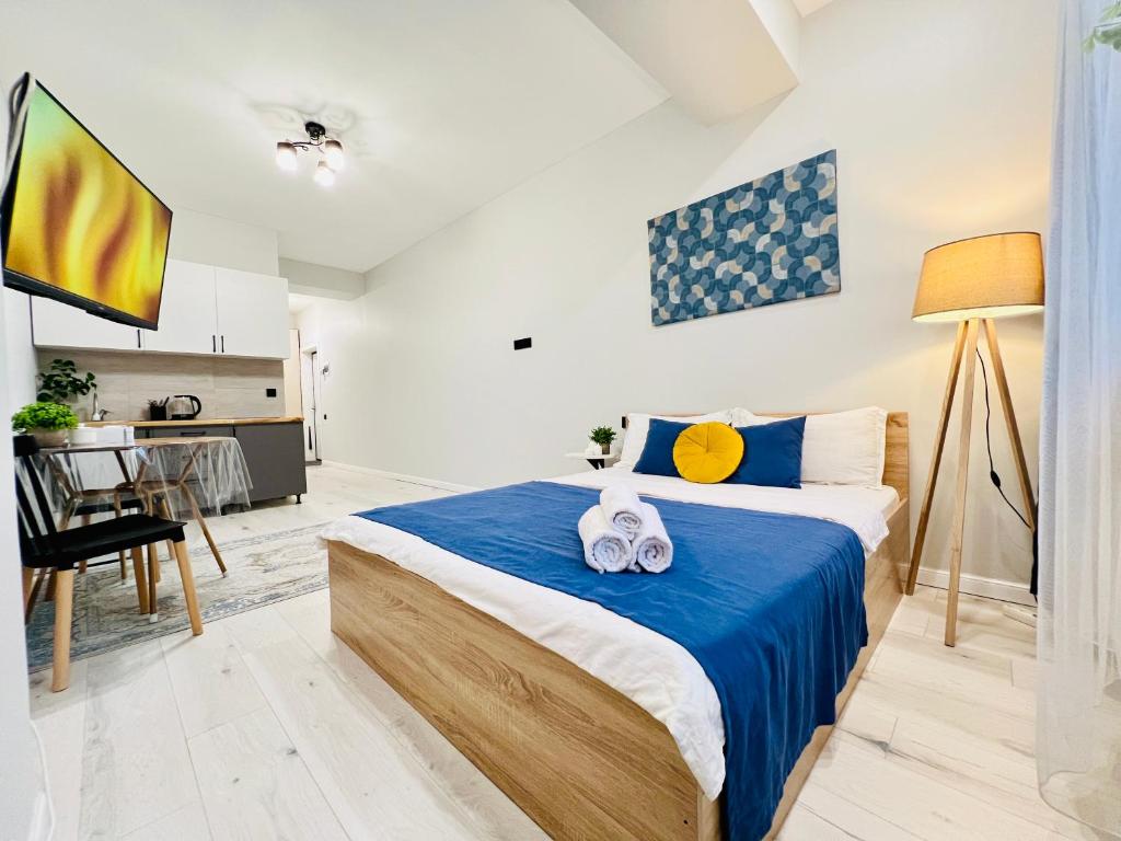 a bedroom with a bed with two towels on it at 417I2 Gray and Yellow apartment Sholpan city in Almaty