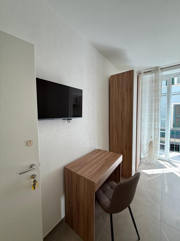 a room with a desk with a chair and a television at Chiara 3 in Cairo Montenotte