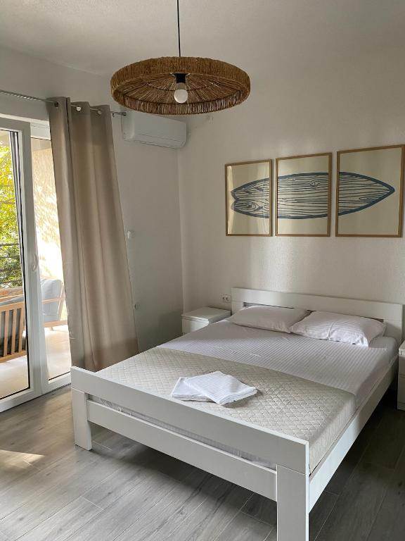 a bedroom with a white bed and a large window at Quattro Rocce Apartments Zelen in Sutomore