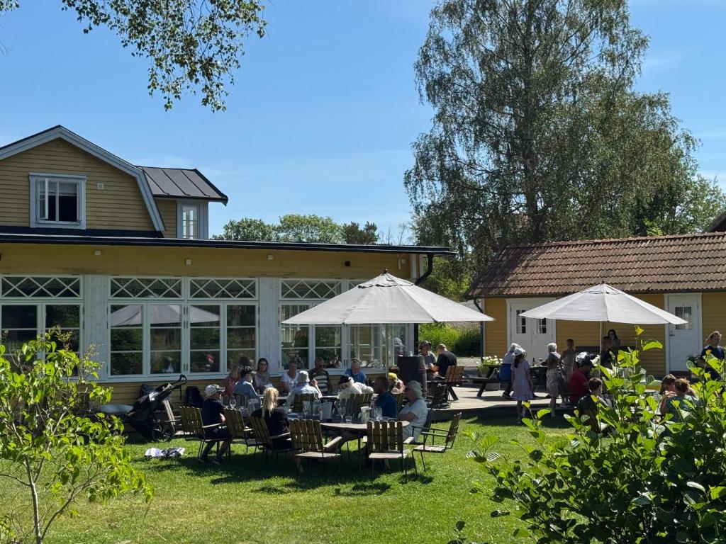 a group of people sitting at tables in front of a building at Möja Värdshus in Möja