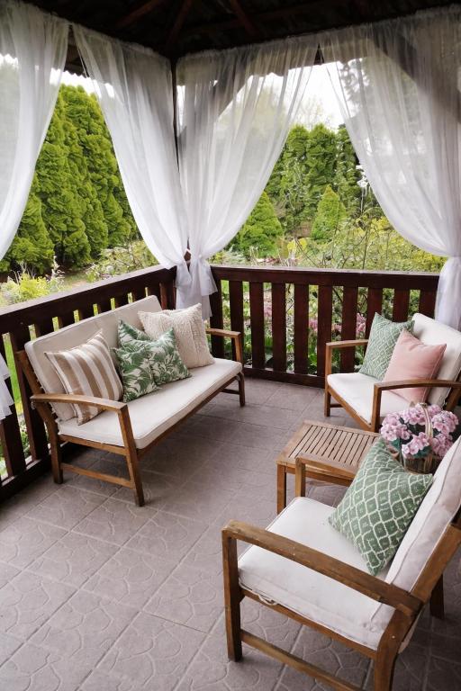 a porch with couches and chairs on a balcony at Agroturystyka Wypoczynek na Wsi in Słowiki Nowe