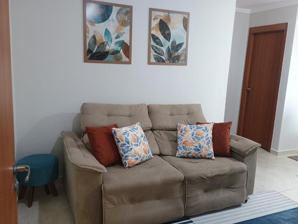 a brown couch in a living room with pillows on it at Casa Bella in Catanduva