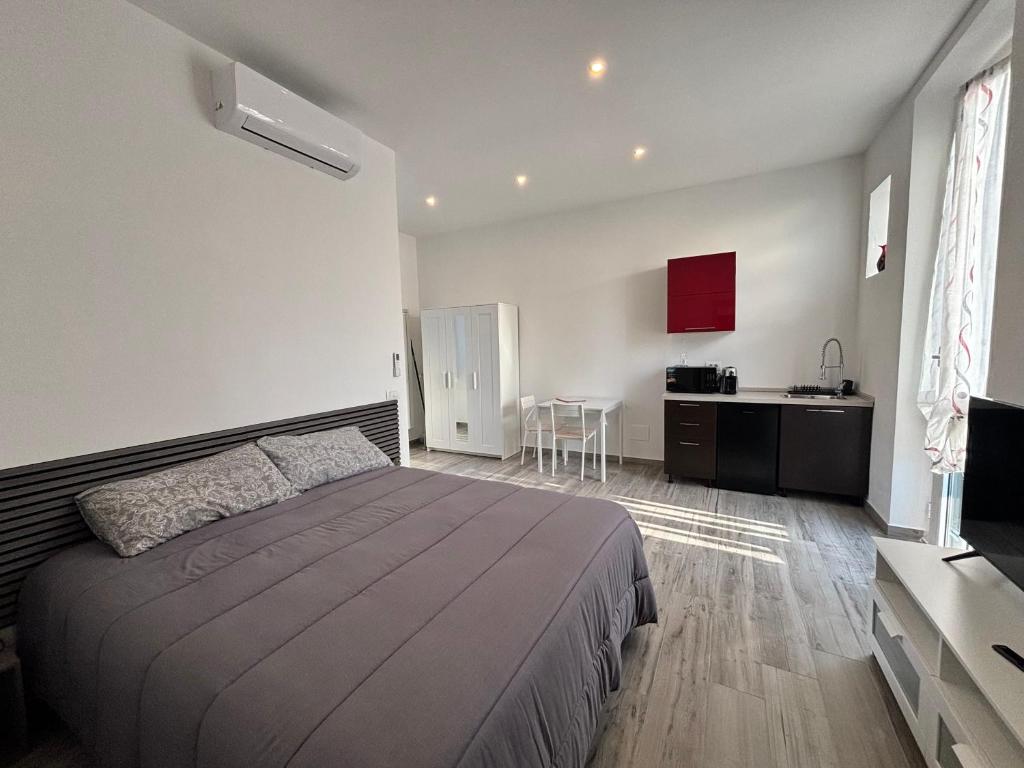 a bedroom with a large bed and a kitchen at Casa di Mile in Rho