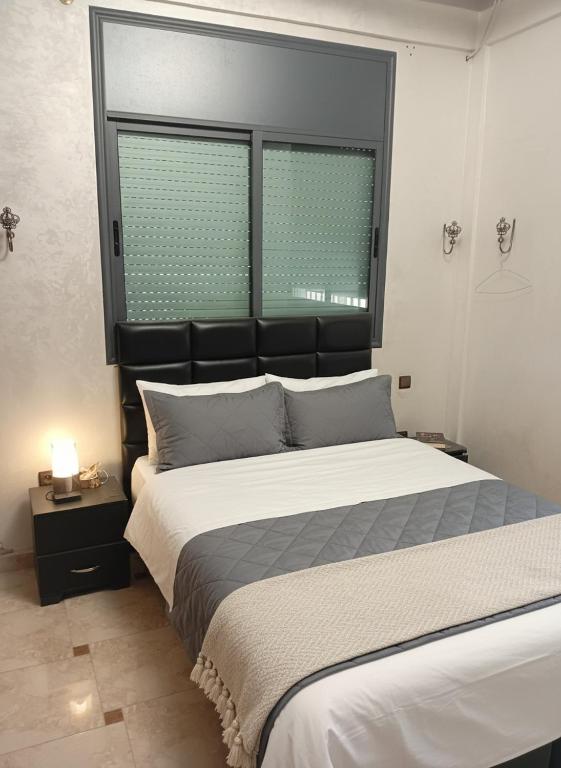 a bedroom with a large bed and two windows at Sidi Rahal Playa beach in Casablanca