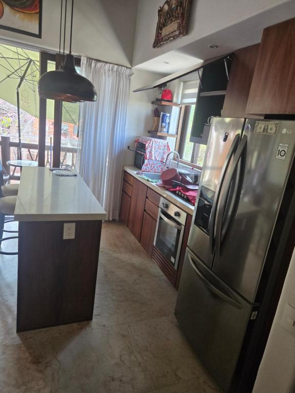 a kitchen with a stainless steel refrigerator and a counter at Condominio Dario 12 in Zihuatanejo