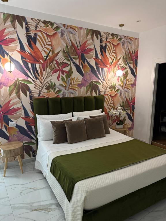 a bedroom with a large bed with a floral wallpaper at Savior Deluxe Rooms in Naples