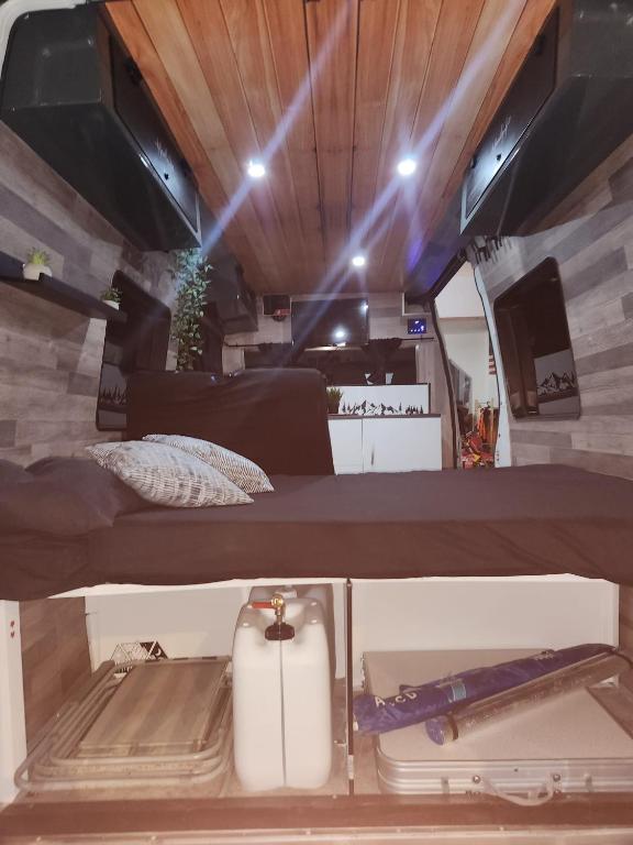 a bed in an rv with a suitcase and lights at Furgocamper in Lanzarote