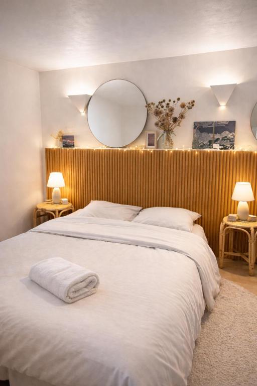 a bedroom with a large white bed and two mirrors at Acmé Appartement 200 m du lac d'Annecy in Angon
