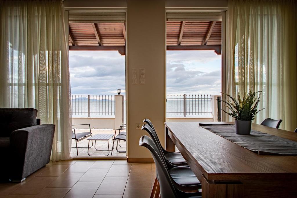 a dining room with a table and chairs and a balcony at Marathon Coastal House in Marathon