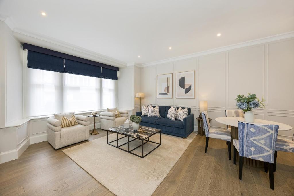 a living room with a couch and a table at Buckingham & Lloyds Knightsbridge in London