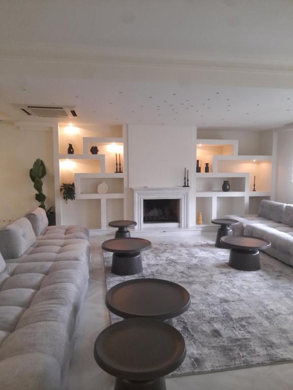 a living room with couches and tables and a fireplace at Kings and Queens 1 in Larisa