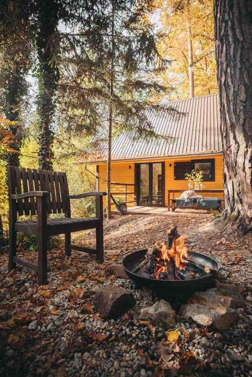 a fire pit next to a bench and a building at Naše chata in Ostrolovský Újezd