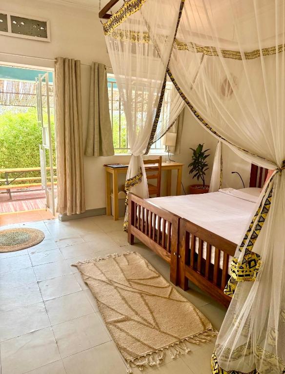 a bedroom with a bed with a mosquito net at Villa Katwe in Masaka