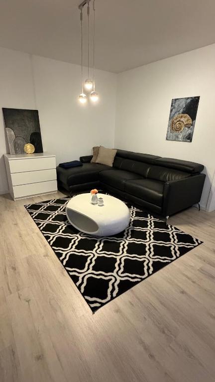 a living room with a black couch and a table at Sunset Suite mit Weitblick in Ditzingen