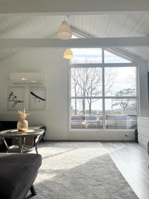 a living room with a table and a large window at Brightside House in Kristiansand