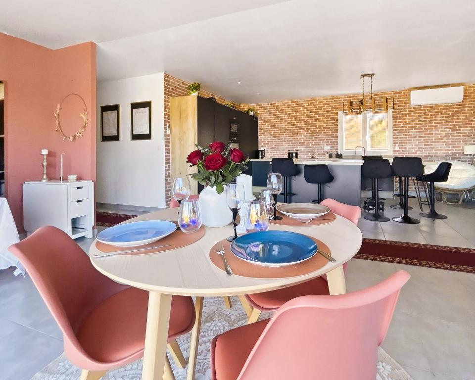 a dining room with a white table and pink chairs at Maison de charme, Gorges Ardèche et Nature in Vagnas