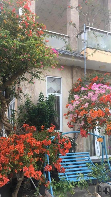 a house with a blue bench and flowers in front of it at Kim An Sadec Garden House in Ấp Tân An (2)