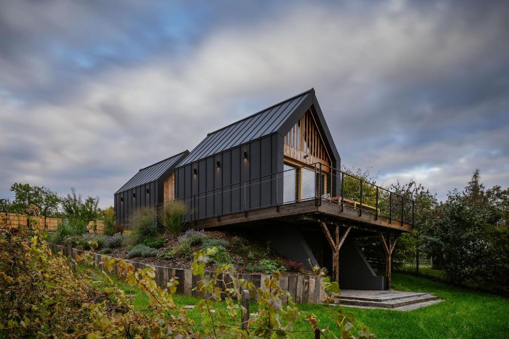a black house with a deck on a hill at Kabiny Kravák in Znojmo