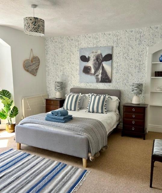 a bedroom with a bed with a picture of a cow at Mews Cottage in Torquay