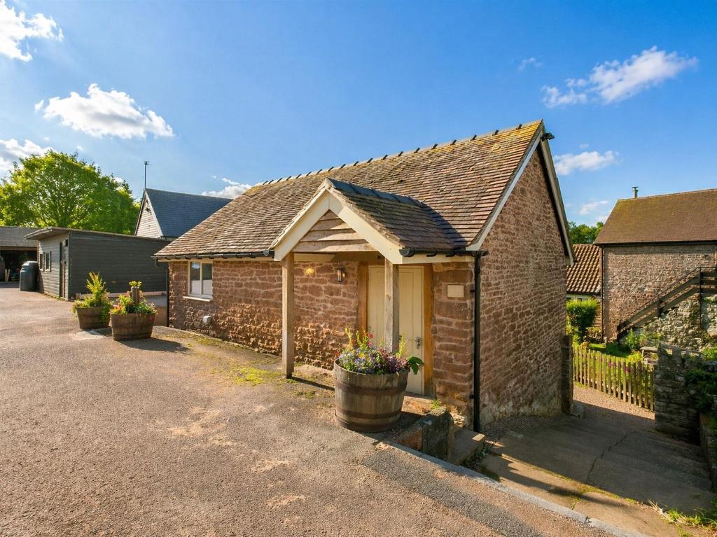 a brick house with a porch and a driveway at Wagtail Lodge in Foy