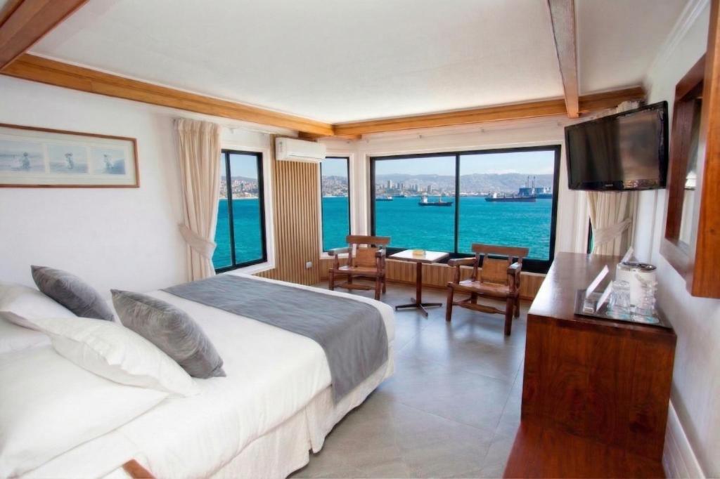 a bedroom with a bed with a view of the ocean at Hotel Oceanic in Viña del Mar