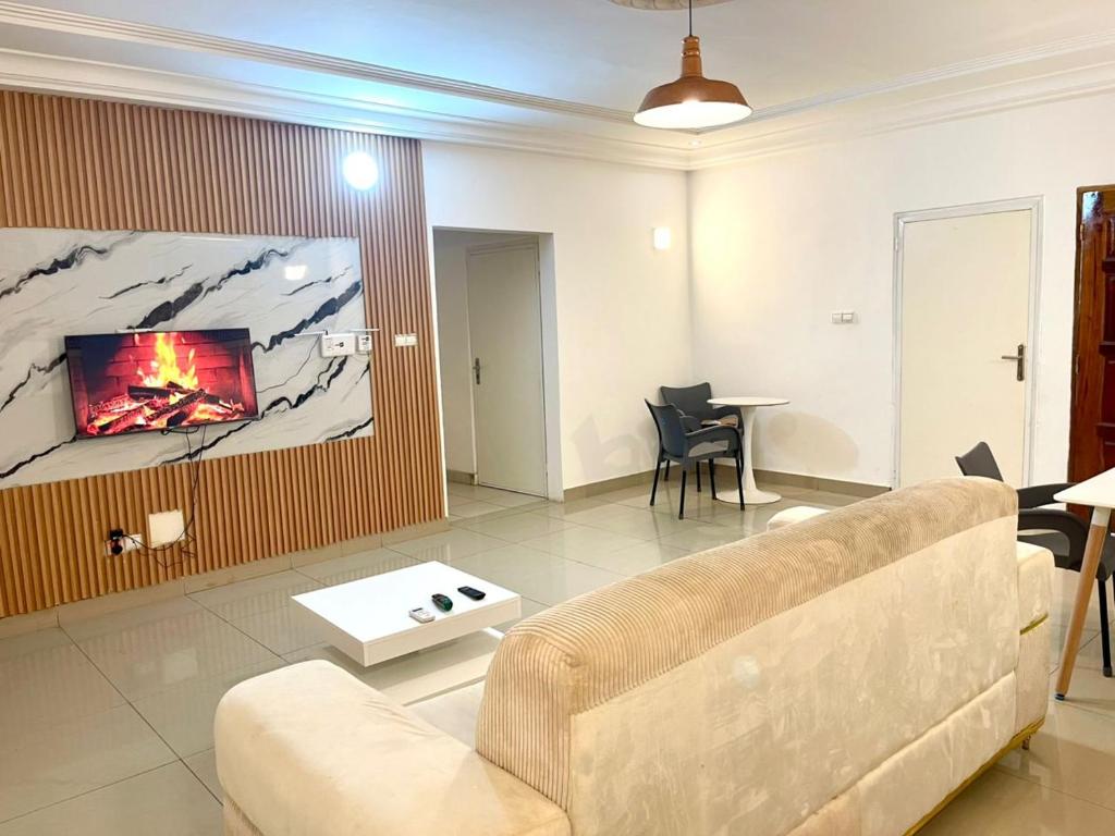 a living room with a couch and a tv at Hebertogo Téléssou in Midja