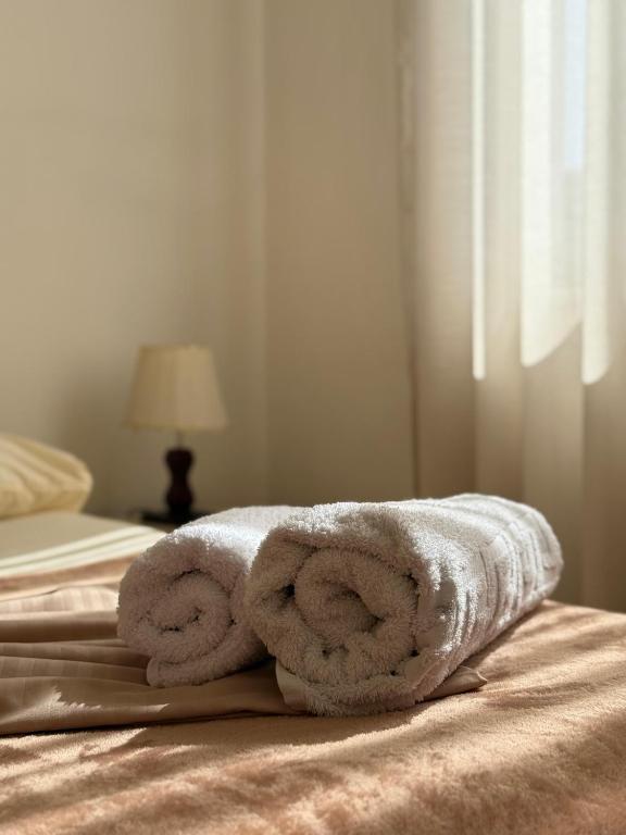 a pile of towels sitting on top of a bed at Valentino Apartments in Shkodër