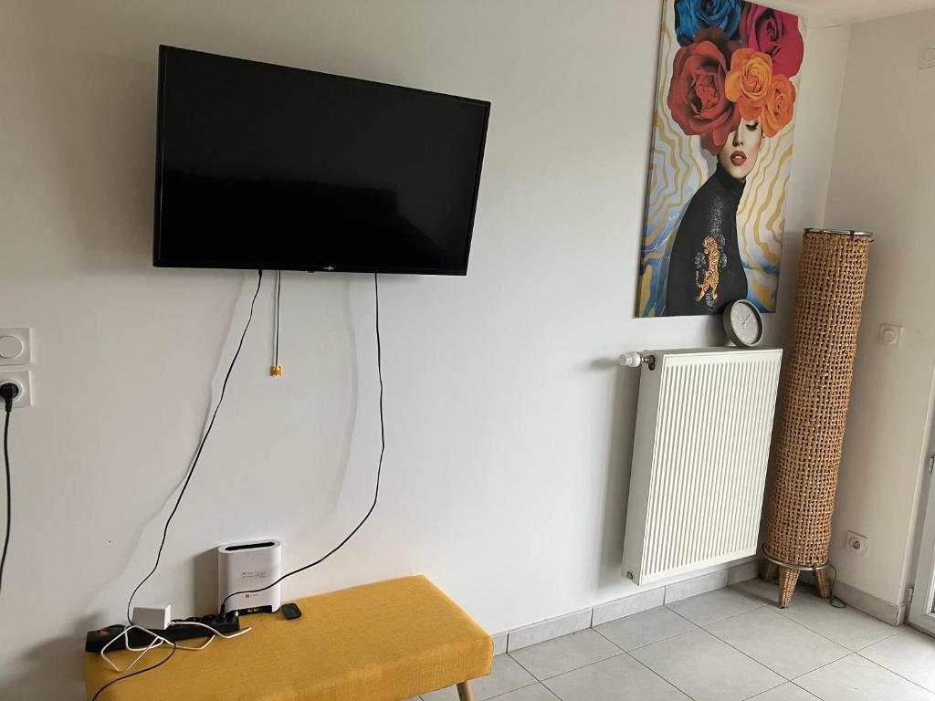 a flat screen tv hanging on a wall at Le 20 Joliot-Studio moderne in Mions