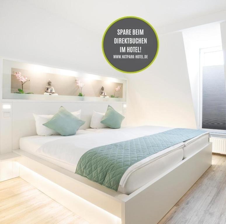 ein weißes Schlafzimmer mit einem großen weißen Bett in einem Zimmer in der Unterkunft NXT PARK Hamburg by ANS in Hamburg
