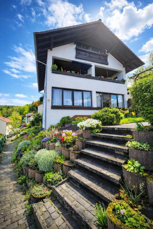 a house with stairs and flowers in front of it at Ferienwohnung Wald-Michelbach in Wald-Michelbach