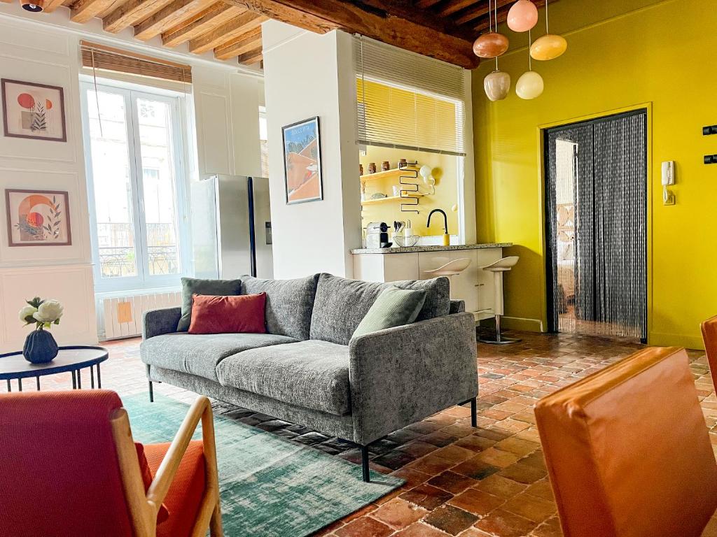 a living room with a couch and a kitchen at Les Appartements d Aristide Avallon in Avallon